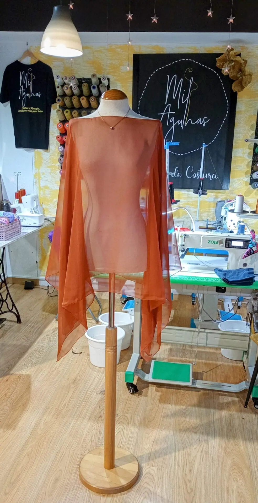 Echarpe em chiffon cor de terracota exposta num manequim no ateliê de costura Mil Agulhas em Coimbra.